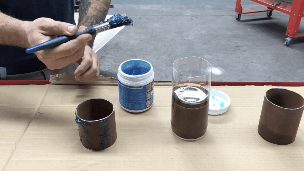 Applying rust remover gel to a steel pipe